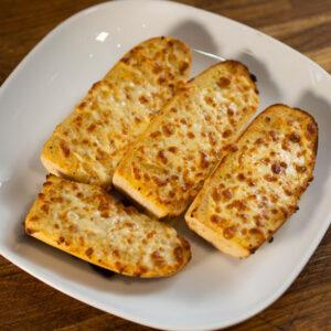 Golden Cheesy Garlic Bread with melted cheese drizzle, a signature from Eastbourne's finest