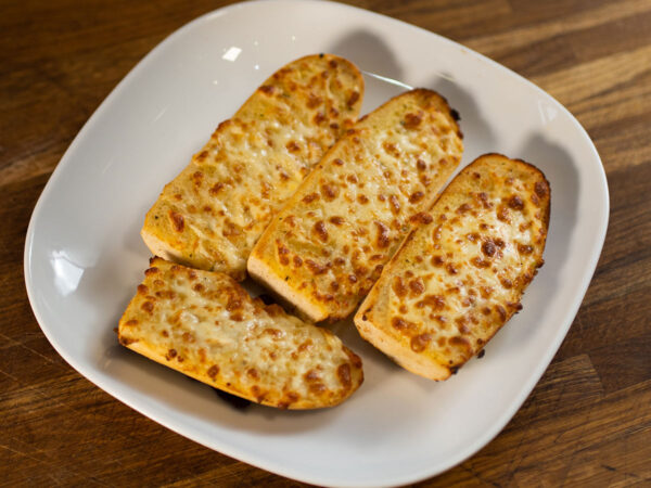 Golden Cheesy Garlic Bread with melted cheese drizzle, a signature from Eastbourne's finest